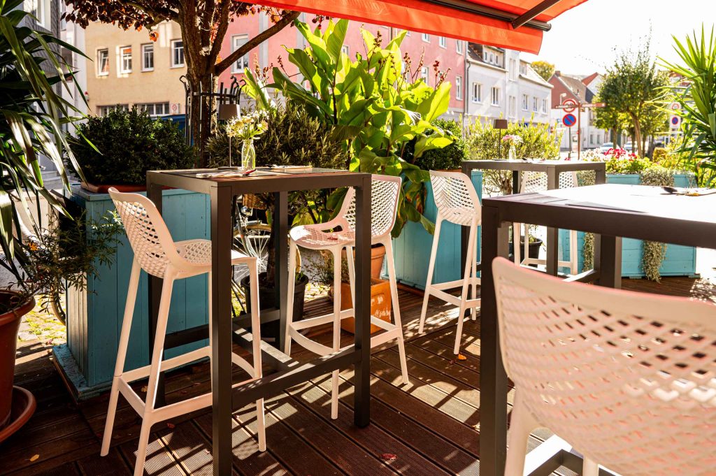 Gedeckte Tische unterm Sonnenschirm auf der Terrasse des Hotel und Restaurant Norddeutscher Bund